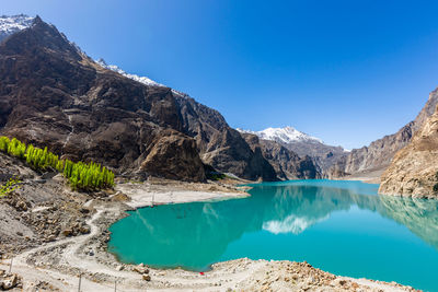 Panoramic view of lake and mountains against clear blue sky