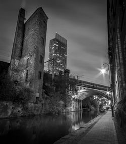 View of canal along buildings at night