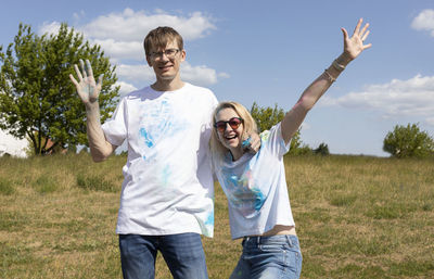 Happy caucasian couple adults posing with colorful dye, powder on clothes on holi colors festival