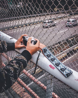 Low section of man seen through chainlink fence