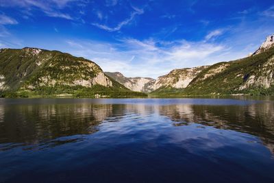 Scenic view of lake and mountains against blue sky