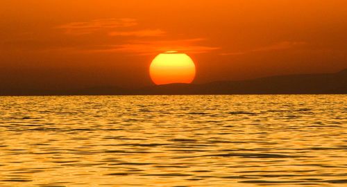 Scenic view of sea against orange sky