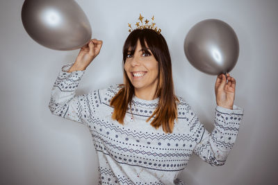 Midsection of woman holding balloons against wall