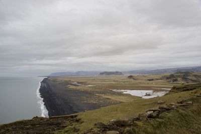 Scenic view of land and sea against sky