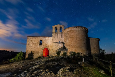 Low angle view of castle against sky at night