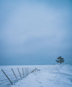 Scenic view of snow covered field against sky