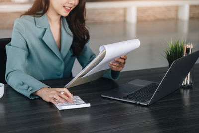 Businesswoman using digital tablet on table