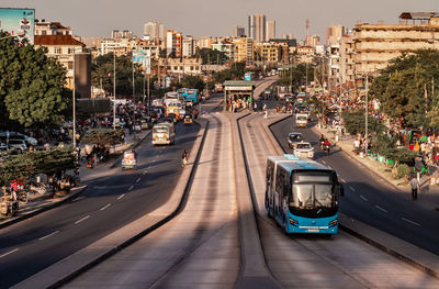 High angle view of a city bus on express road against cityscape 