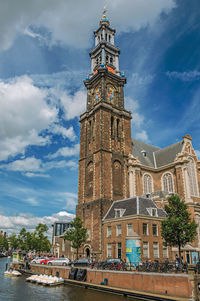 Buildings in city against cloudy sky