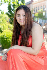 Portrait of teenage girl smiling while sitting outdoors