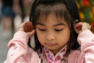 Close-up of cute girl listening music