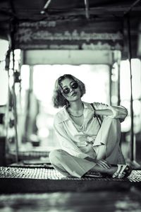 Portrait of young woman wearing sunglasses sitting on swing