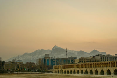 Buildings in city against sky during sunset