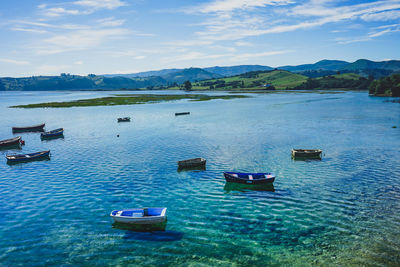 Scenic view of boats in lake against sky