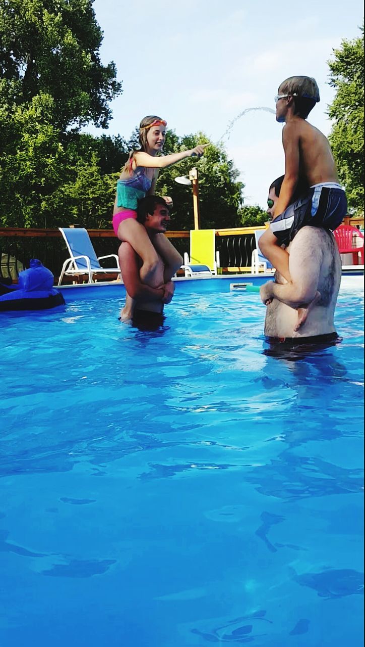 REAR VIEW OF GIRL PLAYING WITH ARMS RAISED