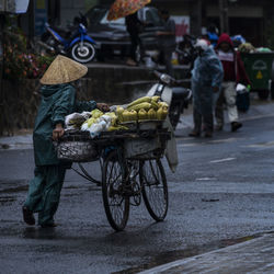 Rear view of man with corns on bicycle