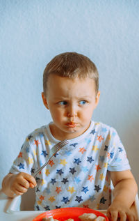 Portrait of cute boy eating food at home