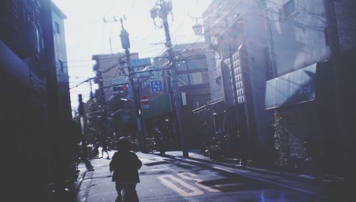 Man walking on road along buildings