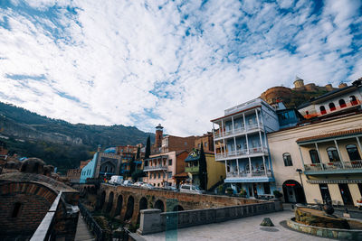 Buildings in city against cloudy sky