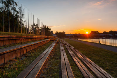 Railroad tracks in city against sky during sunset
