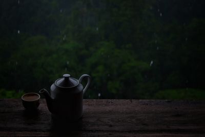 Tea cup on table against trees