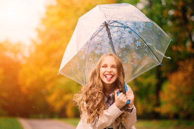 Portrait of smiling young woman holding umbrella