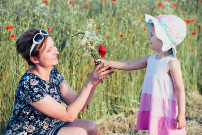 Low section of women with flowering plants