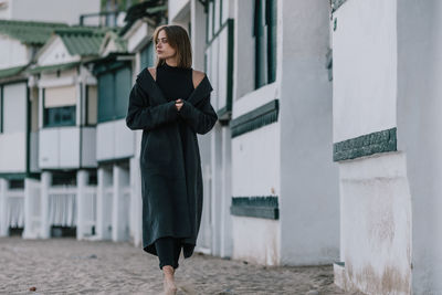 Full length of woman standing against building