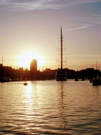 Silhouette sailboats in sea against sky during sunset