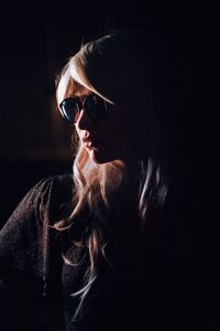 Young woman with long hair against black background