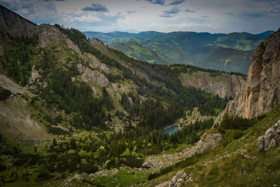 Scenic view of river and mountains against sky