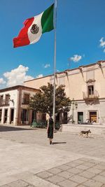 Low angle view of flag against buildings in city