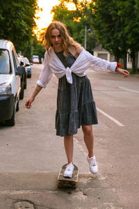 Full length of woman standing on road in city