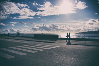 Silhouette man standing by sea against sky during sunset
