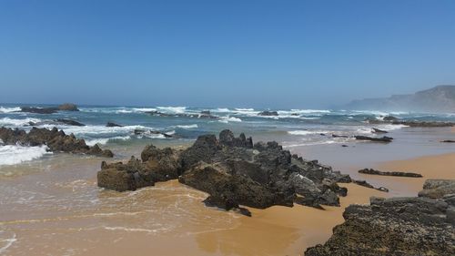 Scenic view of beach against clear sky