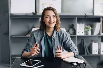 Portrait of young businesswoman using laptop while standing in cafe