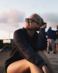 Young woman looking away while sitting outdoors