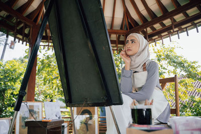 Low angle view of young woman sitting on table