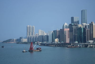 View of sea and buildings against clear sky