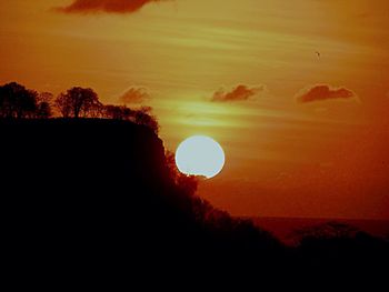 Silhouette landscape against scenic sky