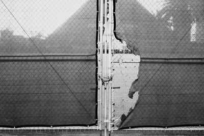 Close-up of chainlink fence against building