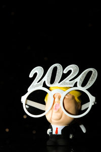 Close-up of woman holding cup with black background