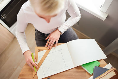 High angle view of woman sitting on table at home