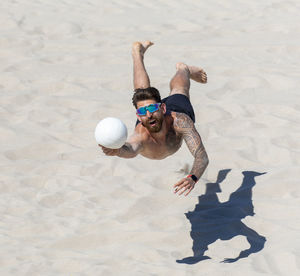 High angle view of men playing with ball on sand