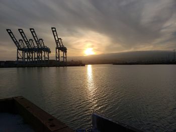 Pier over sea against sky during sunset