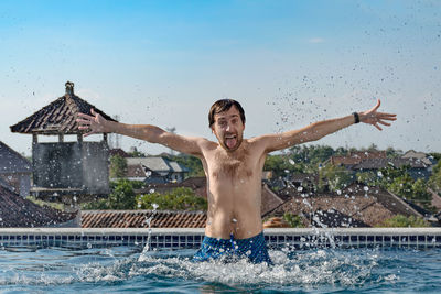 Full length of shirtless man in swimming pool