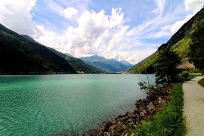 Scenic view of lake by mountains against sky