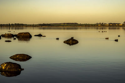 Scenic view of lake against sky during sunset