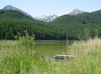 Scenic view of lake by mountains against sky