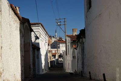 Alley amidst buildings in city against clear sky